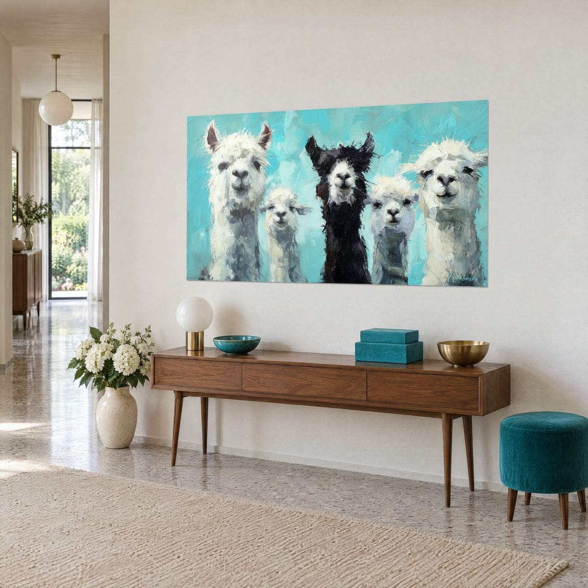 Quadro branco di lama dai musi scuri, vello bianco e cielo verde-azzurro, appeso sopra una console in legno