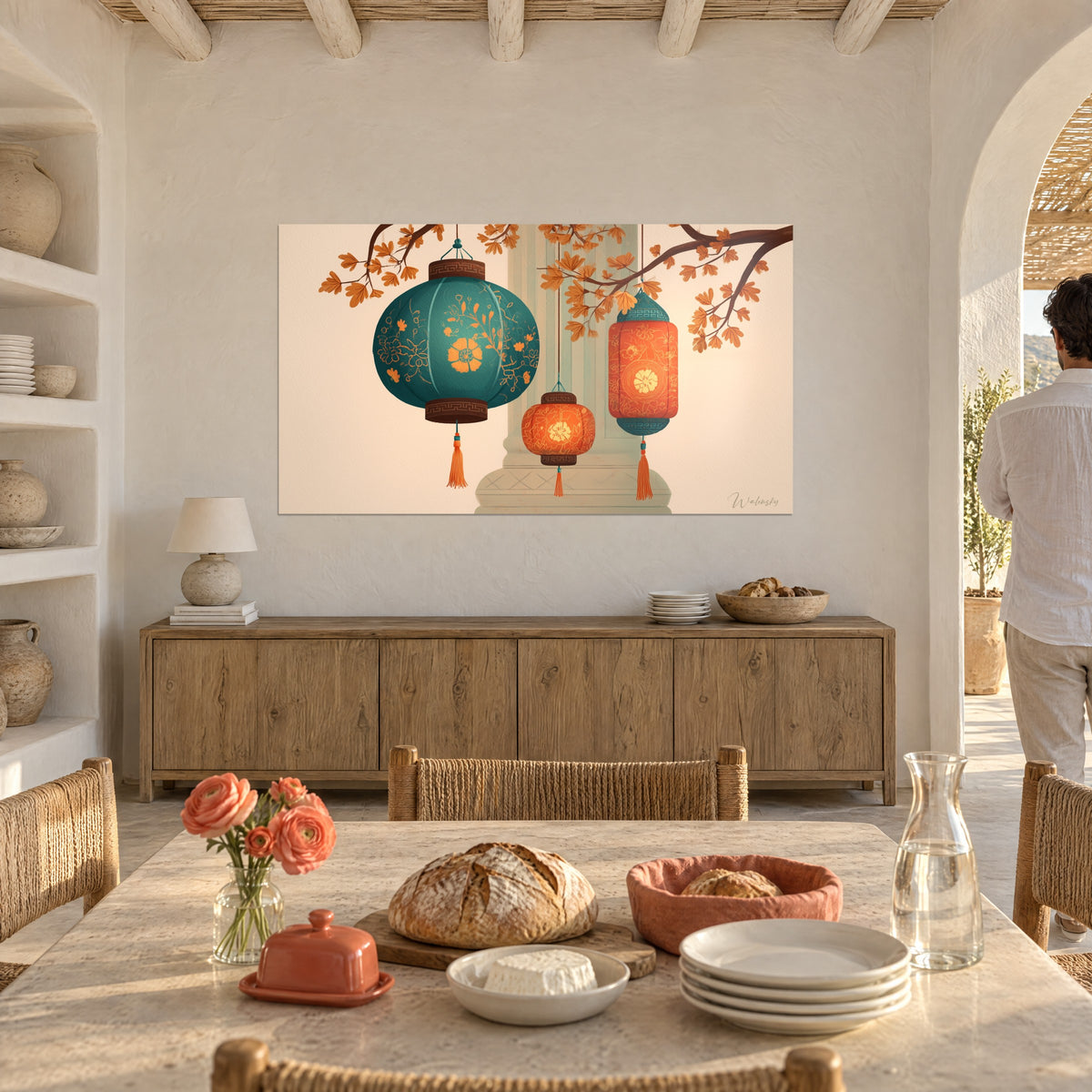 Wall art of orange tasselled lanterns and a blue-green lantern, autumn foliage, hung in a Mediterranean dining room