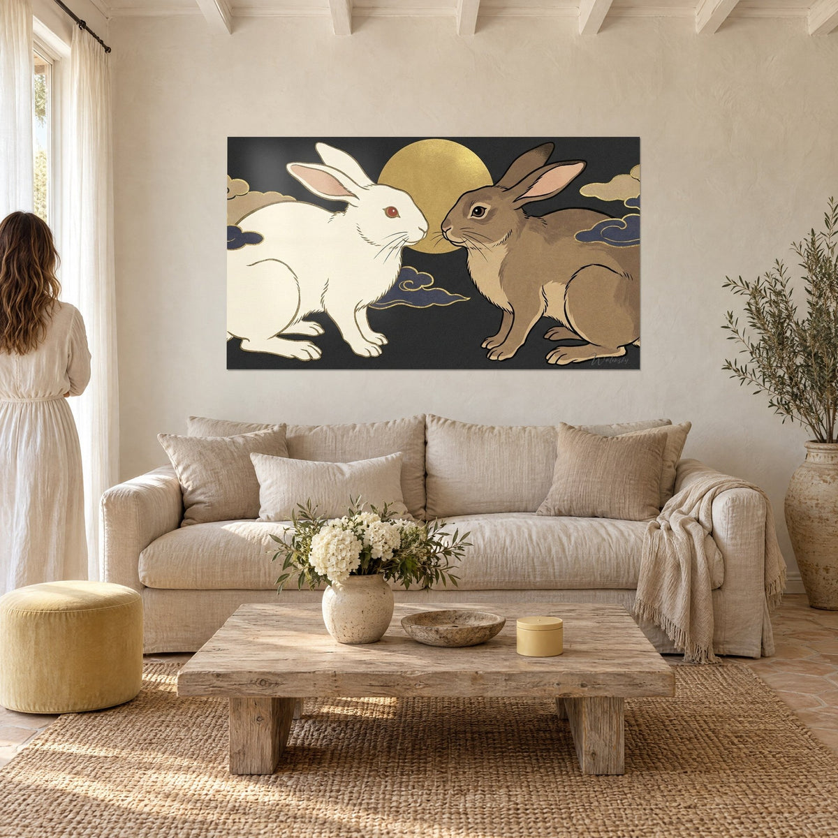 Wall art white rabbit with ruby eyes nose to nose with a brown rabbit, golden moon, hanging above a sofa in a bright living room