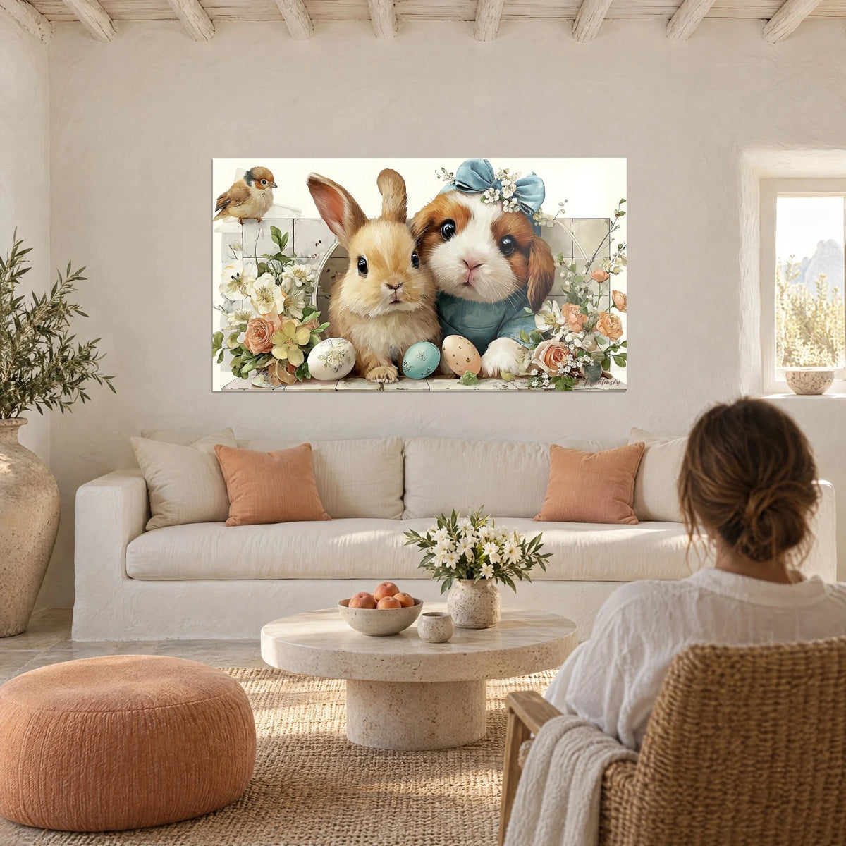 Cuadro de un conejo beige y un cachorro con lazo azul entre rosas melocotón y huevos pastel, encima de un sofá en un salón luminoso