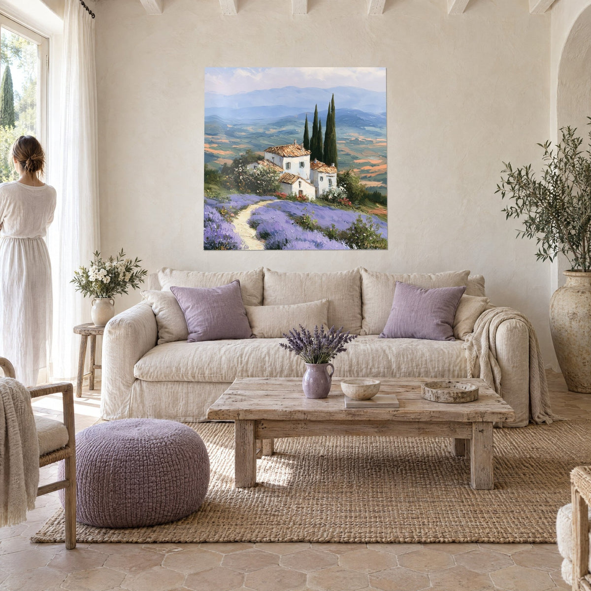Cuadro masía blanca con tejas ocres y cipreses oscuros, campos de lavanda morada, mujer de espaldas, sobre un sofá en un salón luminoso