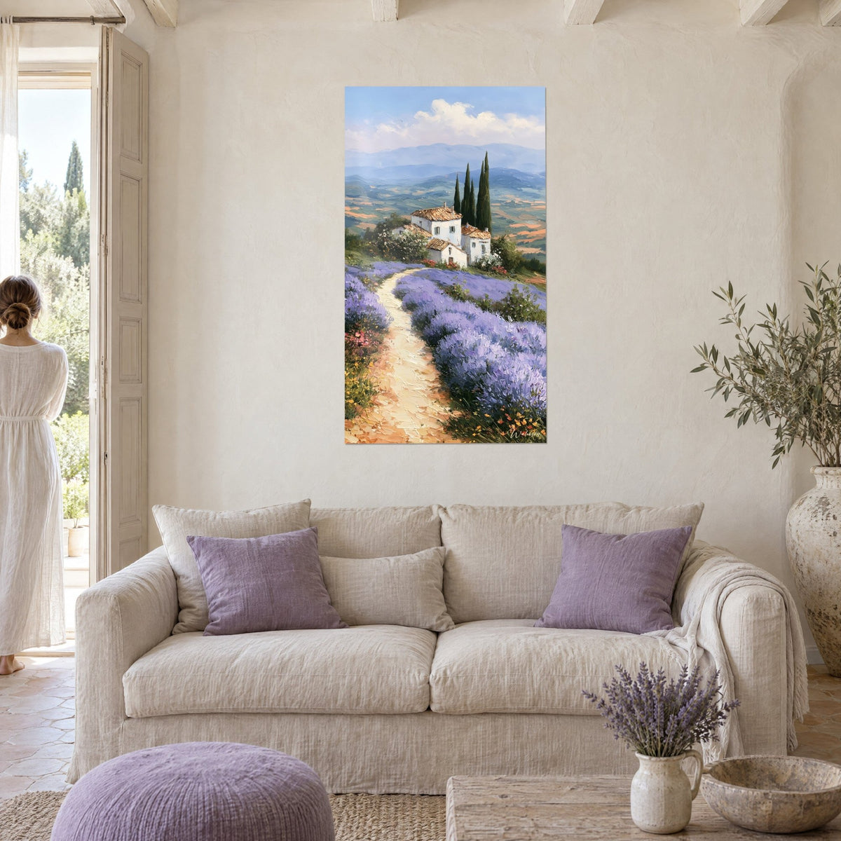 Cuadro masía provenzal de paredes blancas y tejas ocre, lavanda violeta, cipreses, mujer de espaldas sobre un sofá en un salón luminoso