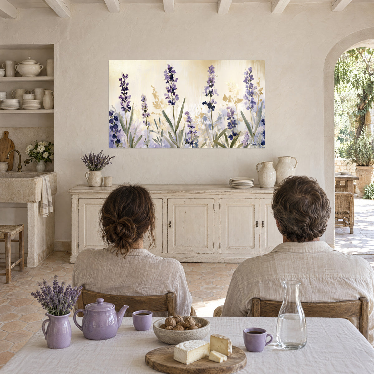 Quadro lavanda selvatica viola e foglie grigio-verdi su tovaglia dorata, coppia di spalle a tavola in una sala voltata bianca