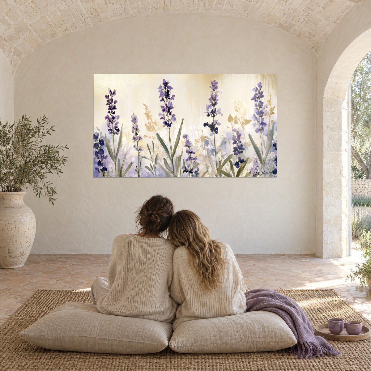 Quadro fioritura di lavanda viola, bagliori d'oro e foschia lilla, due donne di spalle abbracciate su cuscini bianchi in un mas