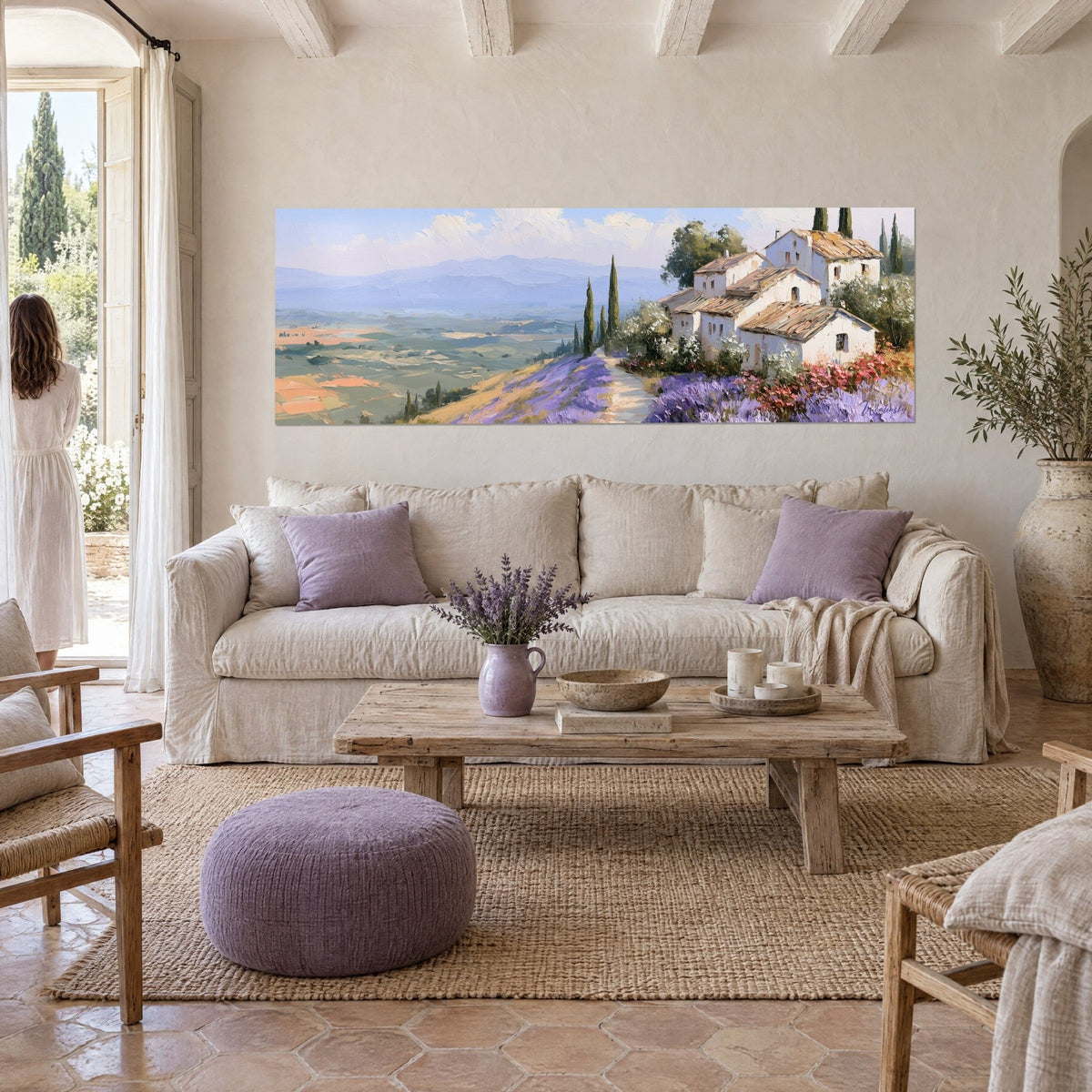 Cuadro pueblo provenzal de tejados ocre y lavanda violeta, dos mujeres de espaldas, sobre un sofá en un salón luminoso