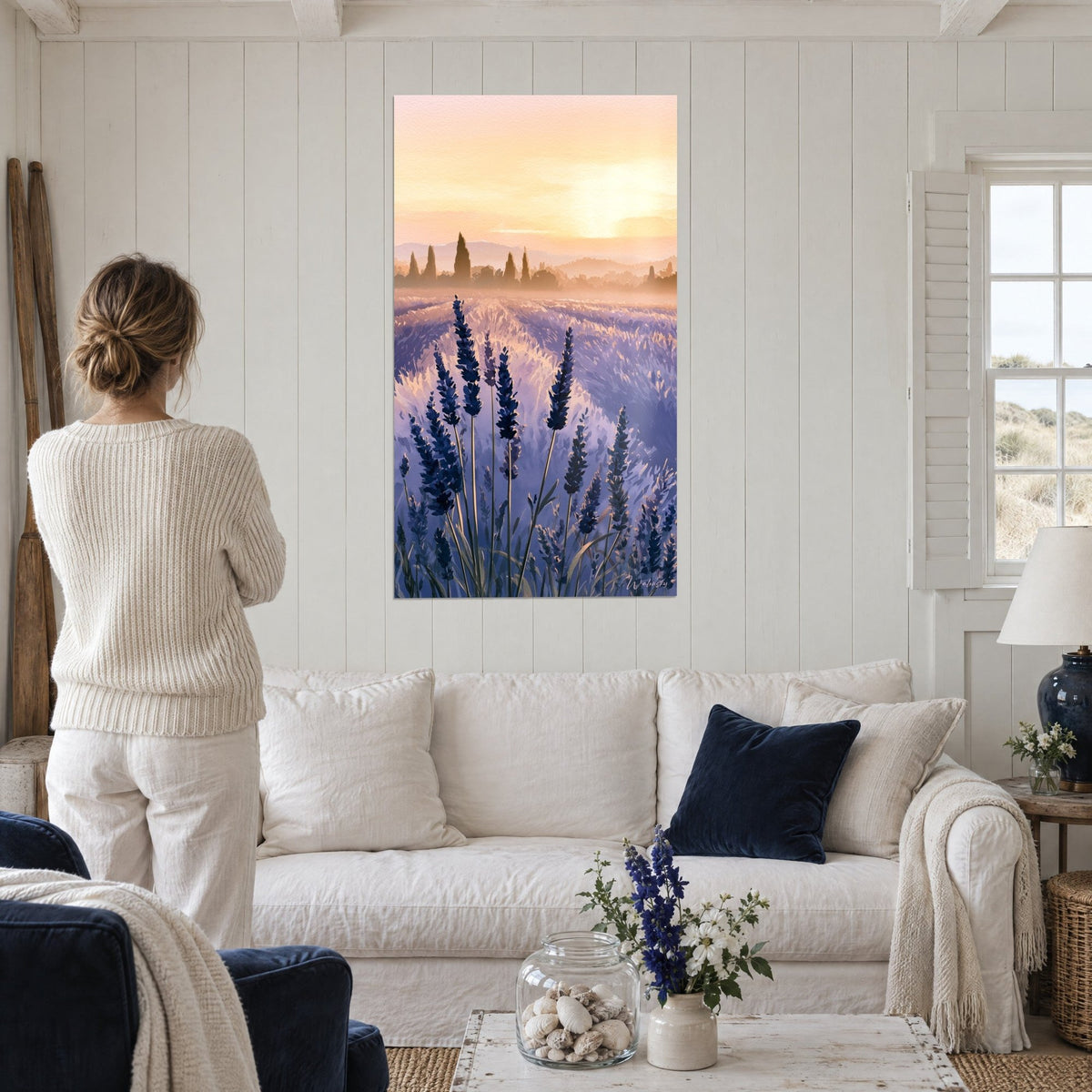 Cuadro campo de lavanda índigo bajo un cielo anaranjado, cipreses brumosos, mujer de espaldas, encima de un sofá en un salón luminoso