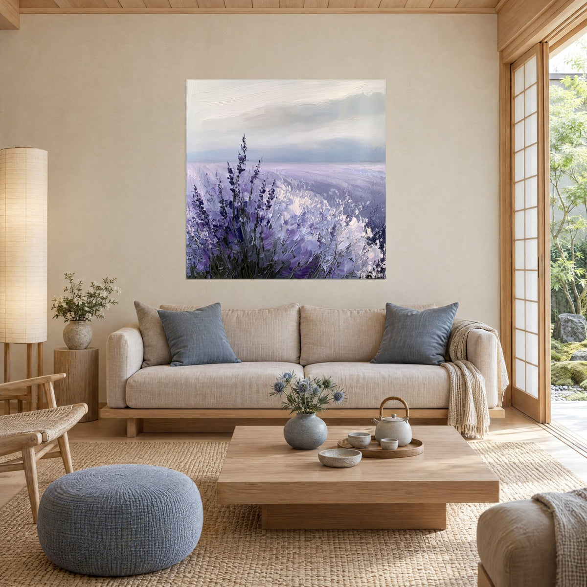 Cuadro campo de lavanda en pasta gruesa, espigas moradas y manta blanca bajo un cielo gris, sobre un sofá en un salón luminoso