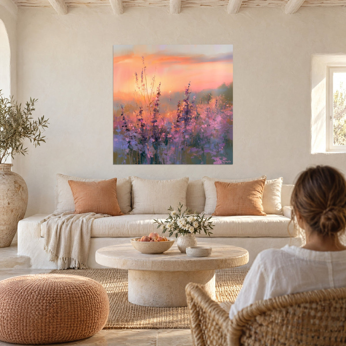 Cuadro lavanda en flor bajo un cielo anaranjado, toques rosas y morados, encima de un sofá en un salón luminoso