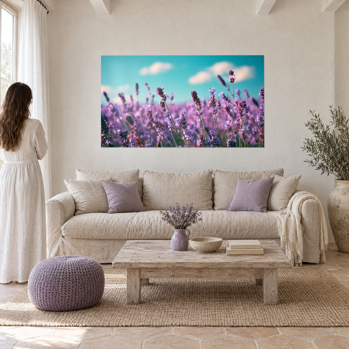 Gemälde Lavendelfeld in Blüte, violette Ähren unter türkisfarbenem Himmel, Frau von hinten im weißen Kleid, über einem Sofa in einem hellen Wohnzimmer