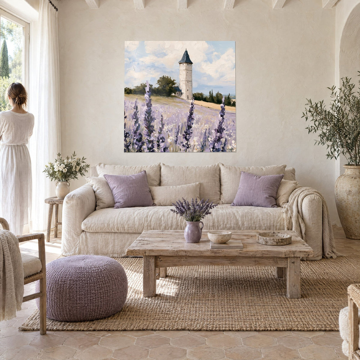 Gemälde Steinturm in hellem Stein über lila und beigen Lavendelfeldern, bewölkter Himmel, über einem Sofa in einem lichtdurchfluteten Wohnzimmer