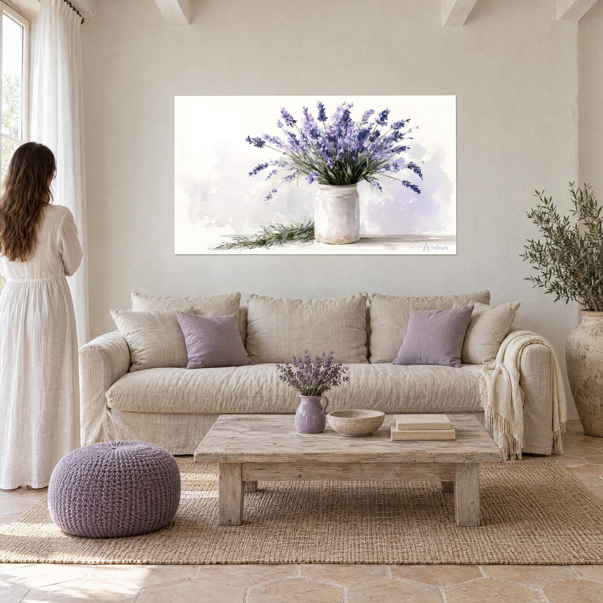 Gemälde Lavendelstrauß als Aquarell, violette Ähren und weiße Vase, beige Wand, Frau im weißen Kleid über einem Sofa in einem hellen Wohnzimmer
