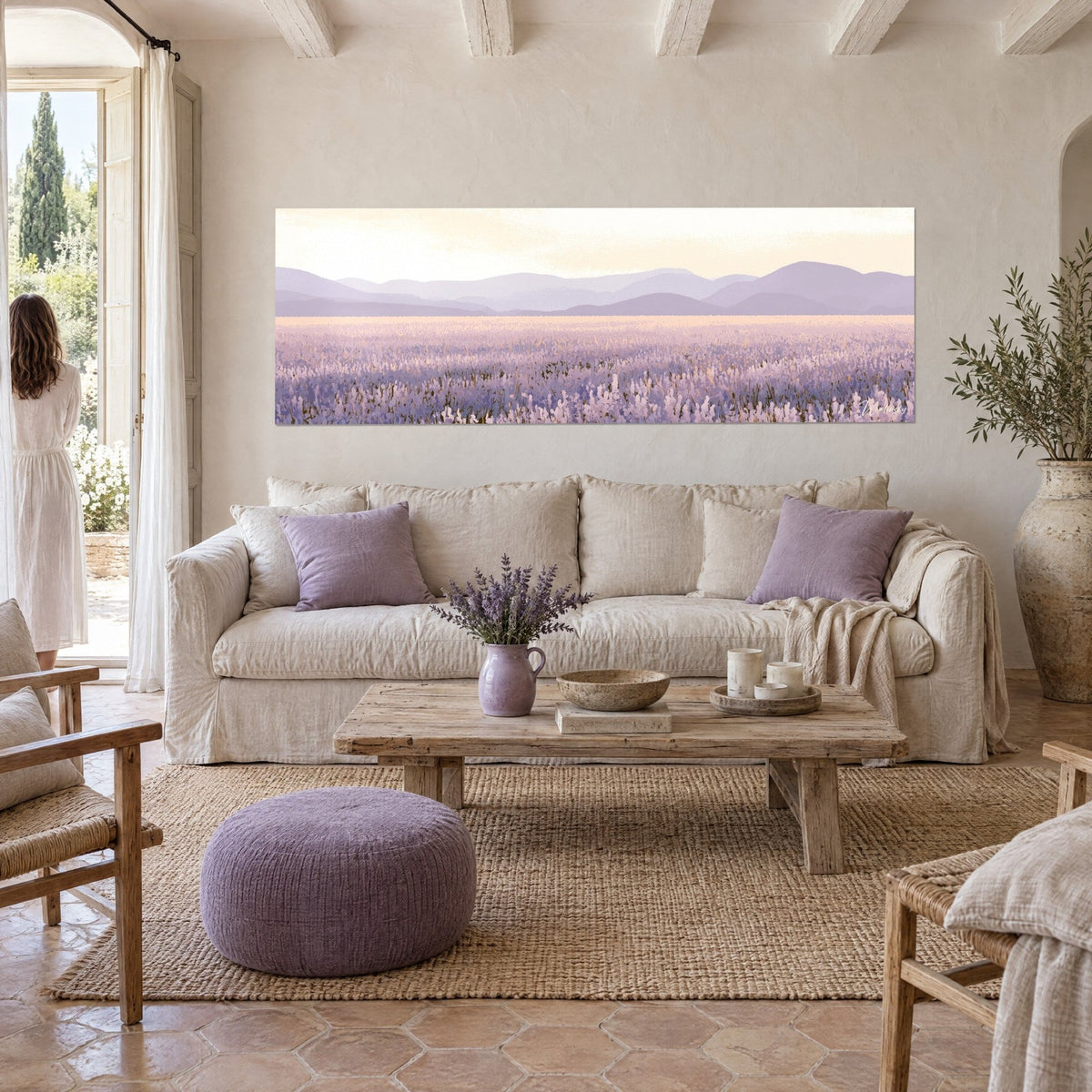 Wall art lavender field in mauve under a cream sky, distant violet hills, seen from behind above a sofa in a bright living room