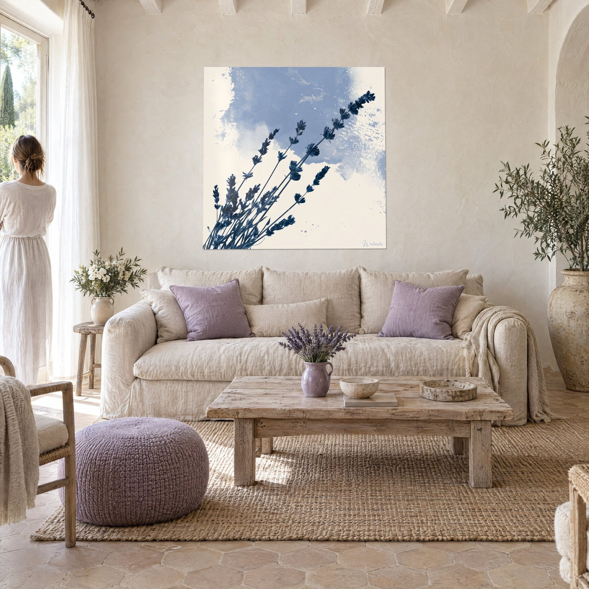 Quadro con rametti di lavanda blu notte su sfondo avorio e una nuvola azzurro polvere, sopra un divano in un soggiorno luminoso