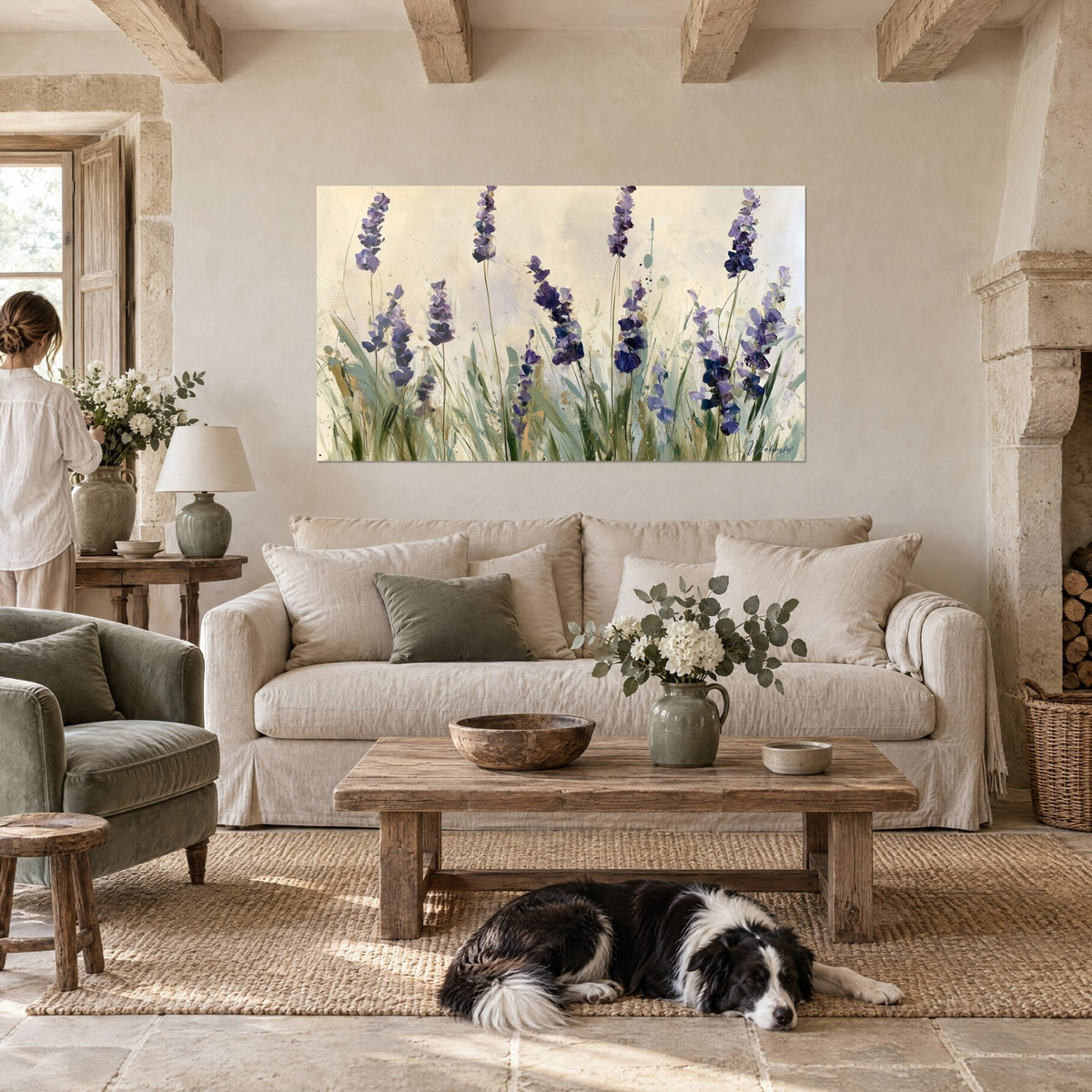Wall art of purple lavender spikes rising on a cream background, sage-green stems, a lying collie beneath, above a sofa in a bright living room