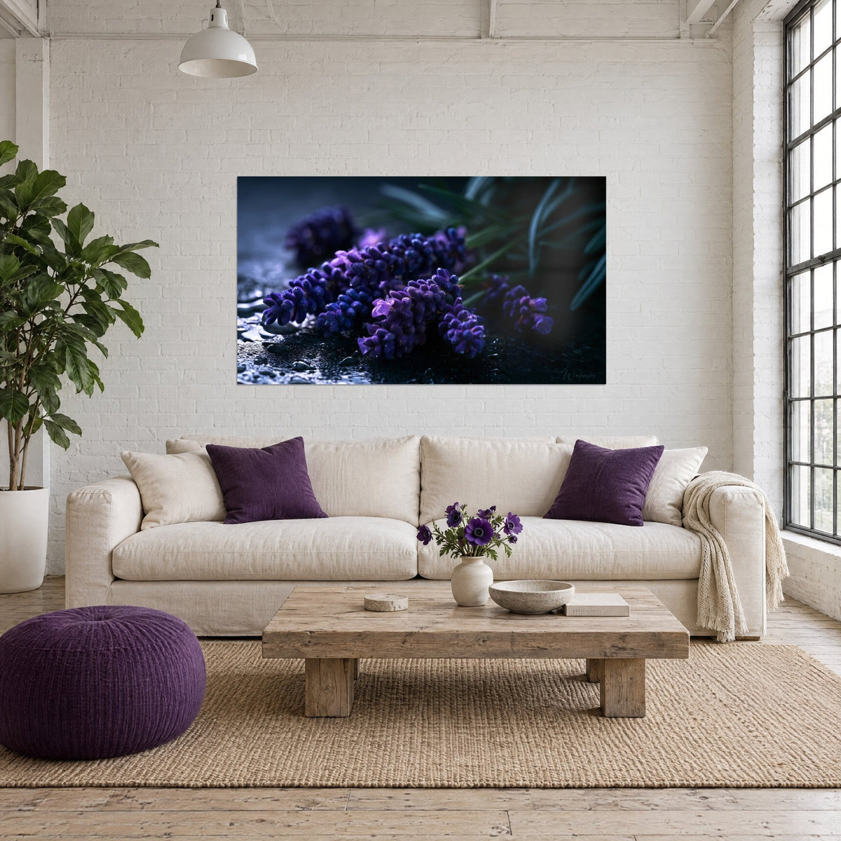 Cuadro espigas de lavanda violeta perladas de gotas de agua sobre fondo negro, follaje verde oscuro, encima de un sofá en un salón luminoso