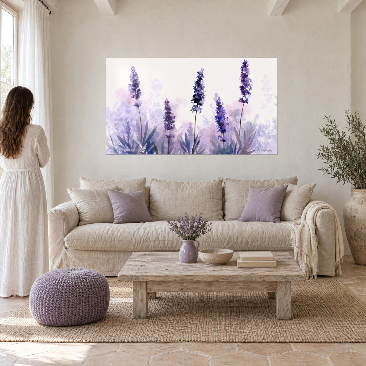 Gemälde Lavendelähren in Violett auf rosécremefarbenem Hintergrund, bläulich belaubt und durchscheinend, eine Frau von hinten über einem Sofa in einem hellen Wohnzimmer