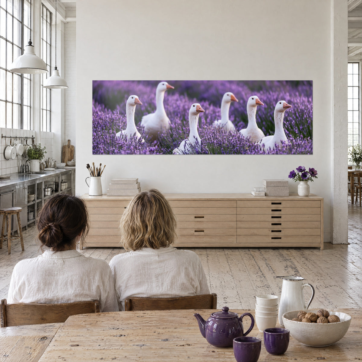 Tableau palmipèdes immaculés au bec abricot entourés de fleurs violettes et de tiges vertes, deux personnes de dos près d'une table