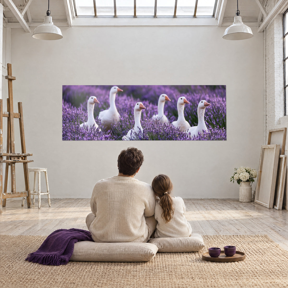 Tableau panorama d'oies crème et de lavandes violettes, un couple de dos assis sur un coussin devant un chevalet dans un loft