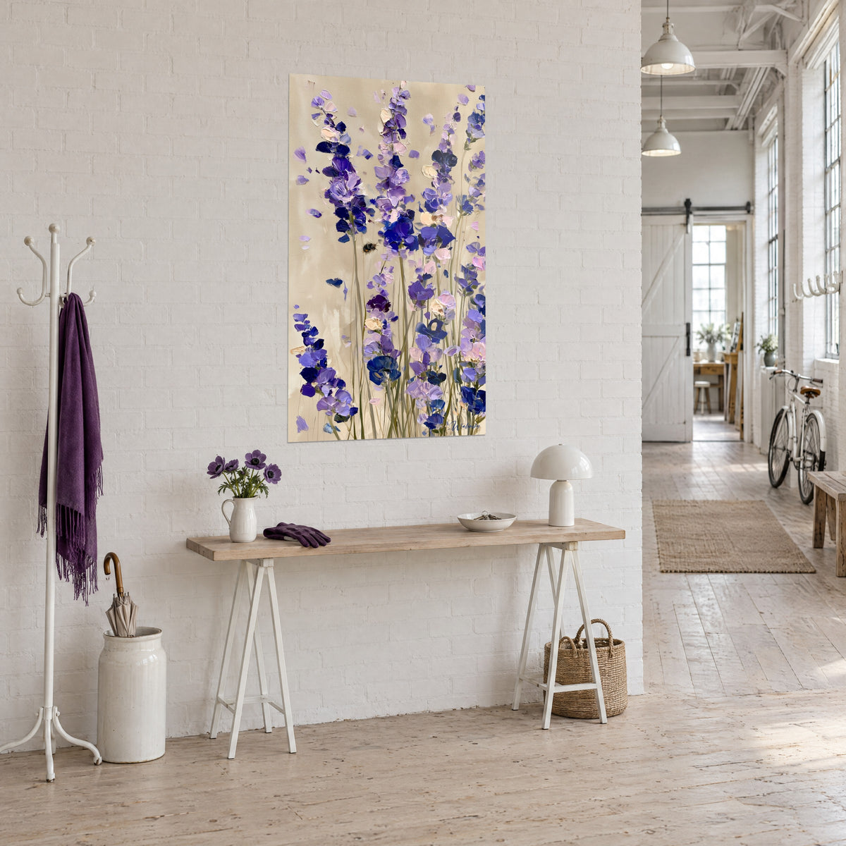 Quadro delphinium blu notte e lilla, petali rosa pallido su fondo beige, vista di tre quarti in un loft d'artista