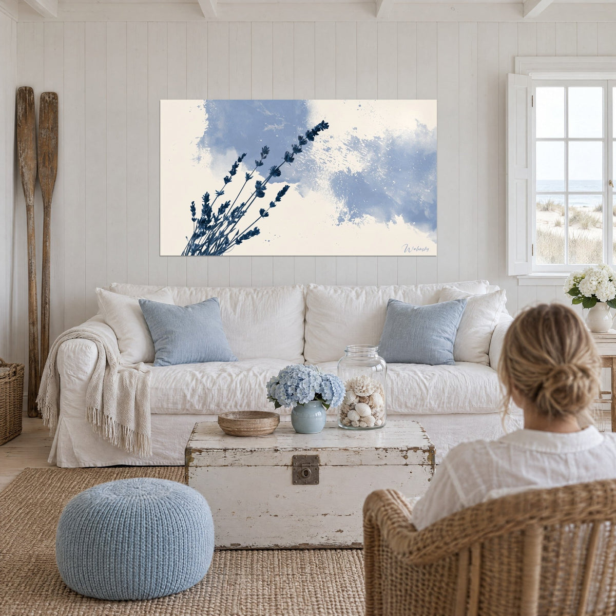 Cuadro ramo de lavanda azul marino sobre nubes de tinta azul cielo y fondo marfil, encima de un sofá en un salón luminoso