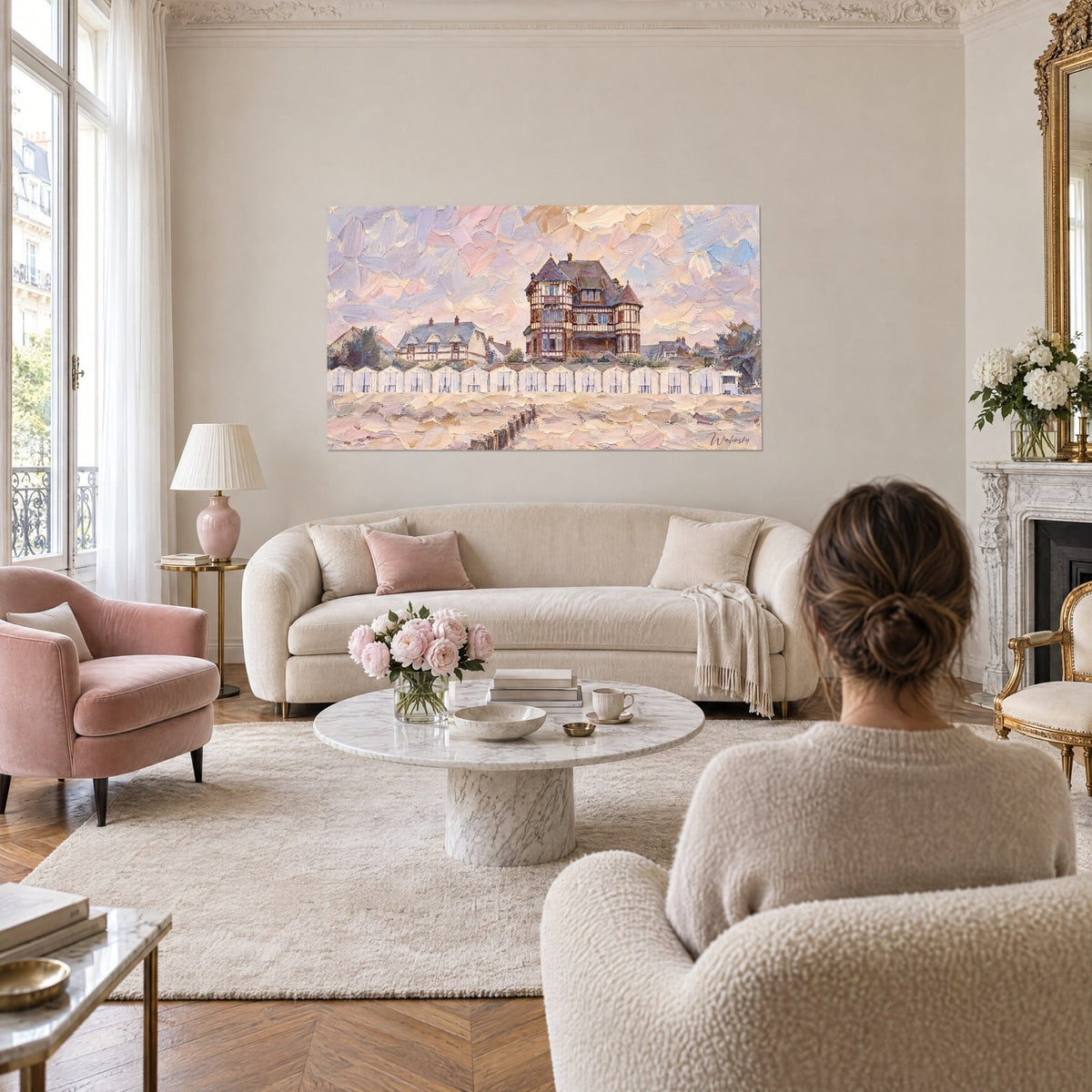 Tableau villa normande à colombages bruns sur ciel rose et mauve, cabines blanches alignées, au-dessus d'un canapé dans un salon lumineux