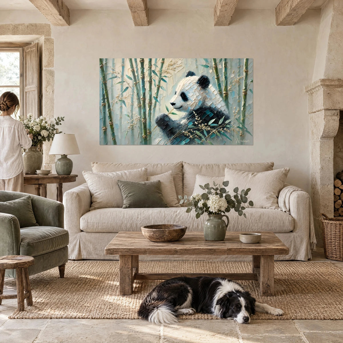 Gemälde Riesenpanda beim Knabbern an einem Bambusstängel, blaugrüne und goldene Bambusblätter, eine Frau und ein schwarz-weißer Collie über einem Sofa in einem hellen Wohnzimmer