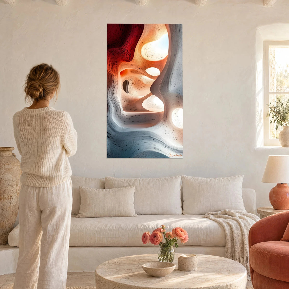 Wall art sculpted grotto with ivory and carmine red layers, windows of light, woman seen from behind, above a sofa in a bright living room