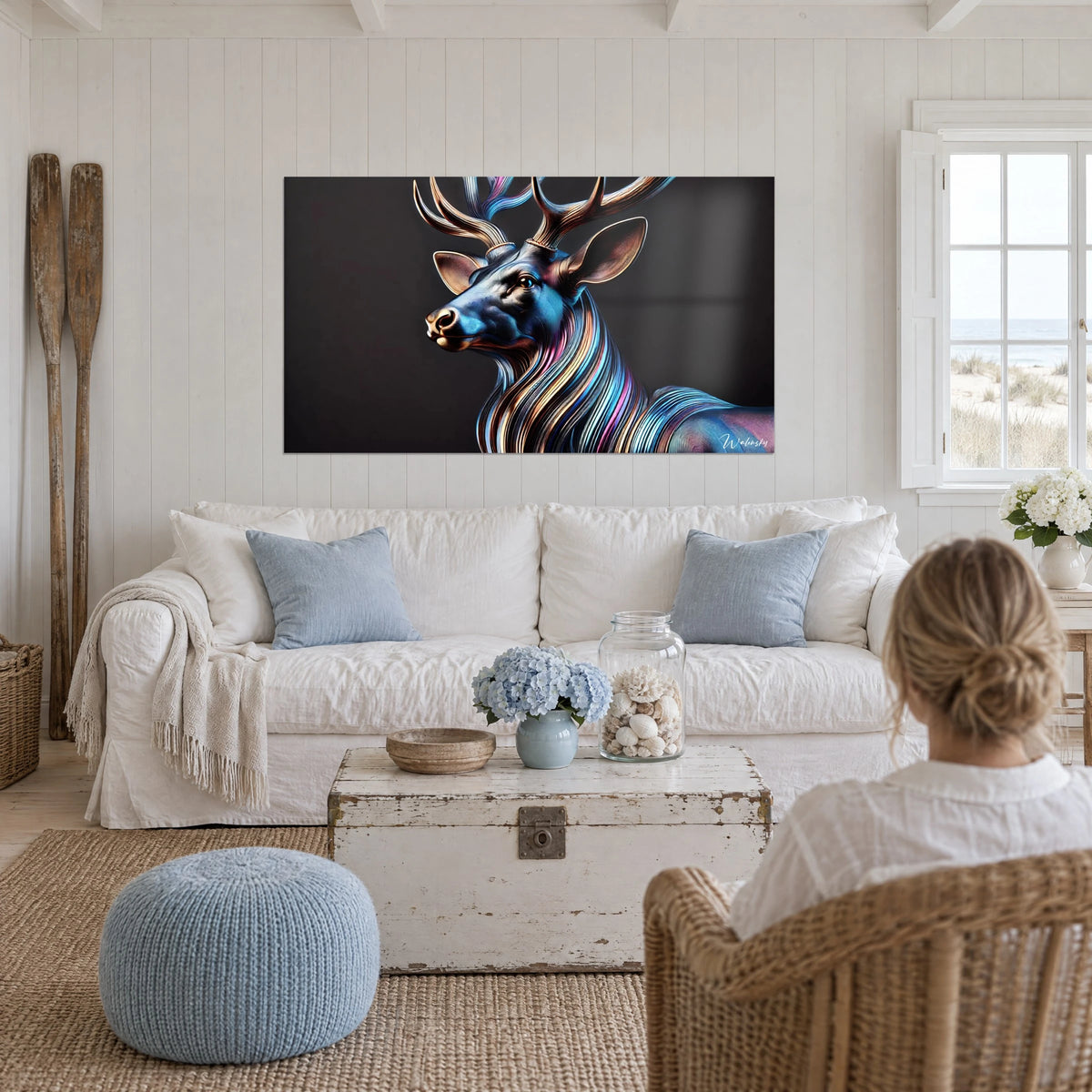 Gemälde Hirsch in Schillerfarben mit kupferfarbenem Geweih, blau und rosa gestreifte Mähne auf schwarzem Grund, über einem Sofa in einem hellen Wohnzimmer