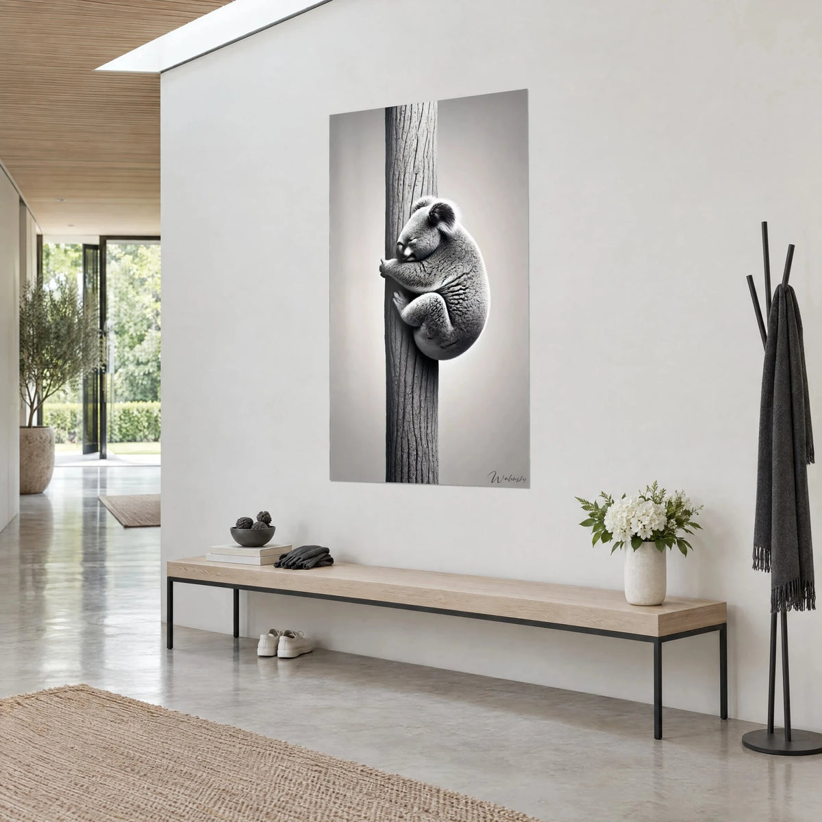 Wall art of a marsupial nestled against striated bark, black and white with soft shades of grey, beside a light wooden bench and a vase of flowers