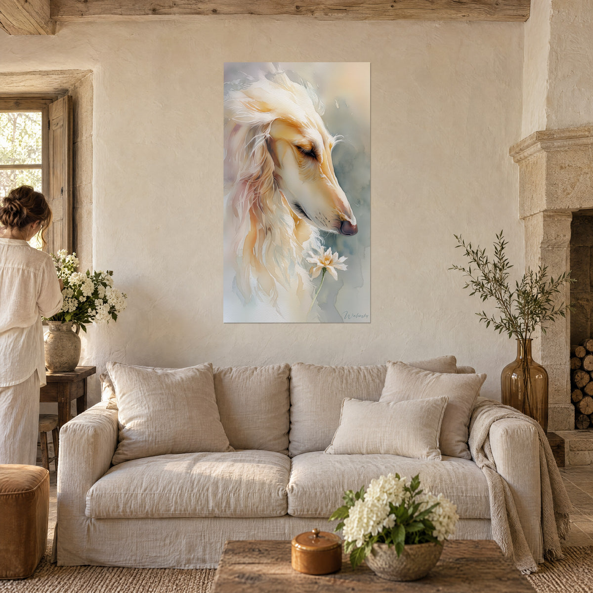 Schilderij Afghaanse windhond aquarel, crème en goudocker, snuit naar een witte bloem geneigd, boven een bank in een lichte woonkamer