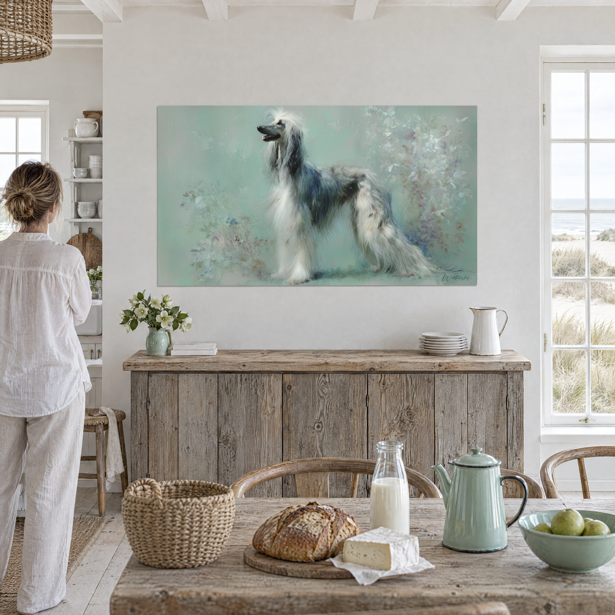 Wall art of an Afghan hound in profile, long ivory and slate coat, pink and blue-grey foliage, on a white wall beside a raw wood console