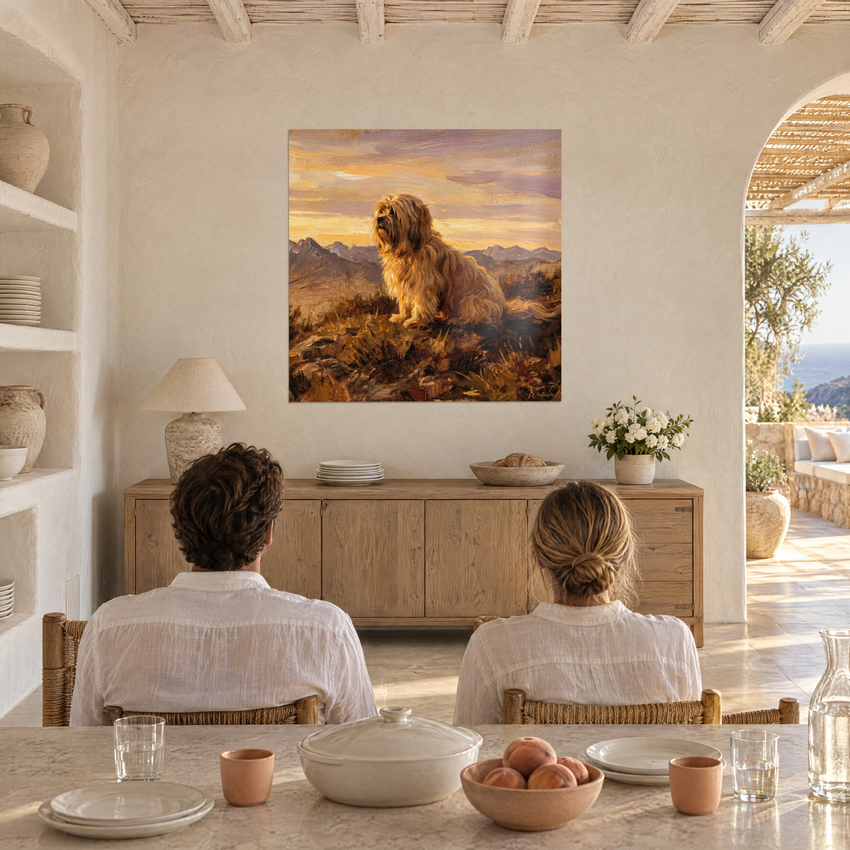 Tableau portrait peint d'un chien barbu aux poils caramel et crème, montagnes bleutées et ciel safran, couple de dos dans une maison méditerranéenne