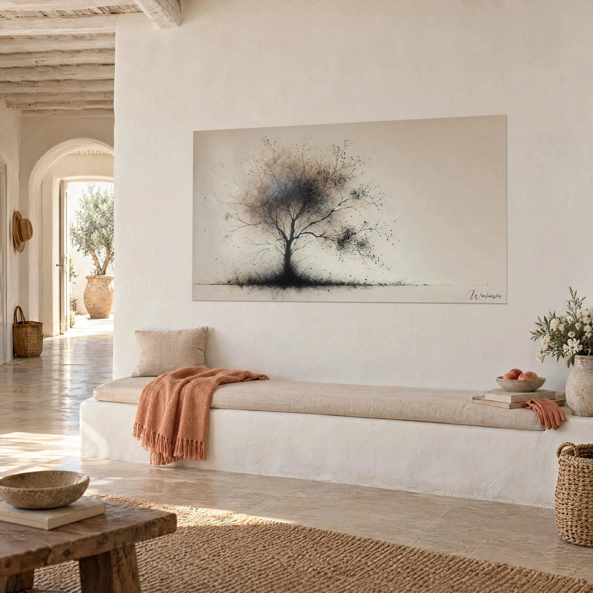 Tableau silhouette d'arbre dénudé aux éclaboussures noires, fond beige et brun rosé, au-dessus d'une banquette blanche et plaid corail