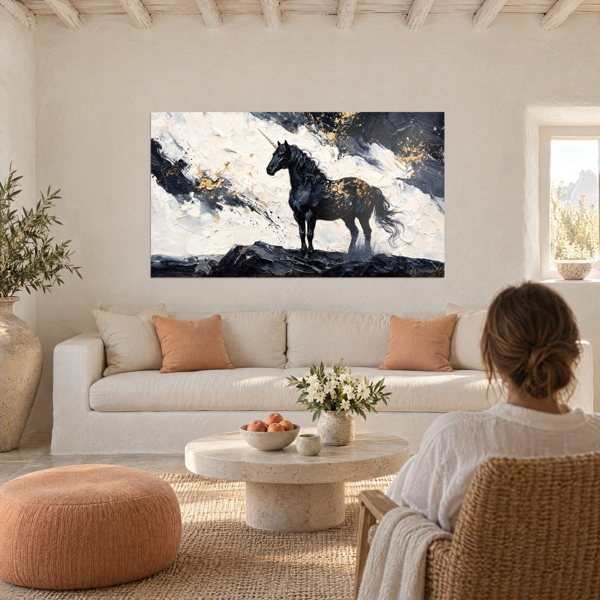 Tableau licorne d'ébène à la corne nacrée, éclats d'or sur fond crème, au-dessus d'un canapé dans un salon lumineux