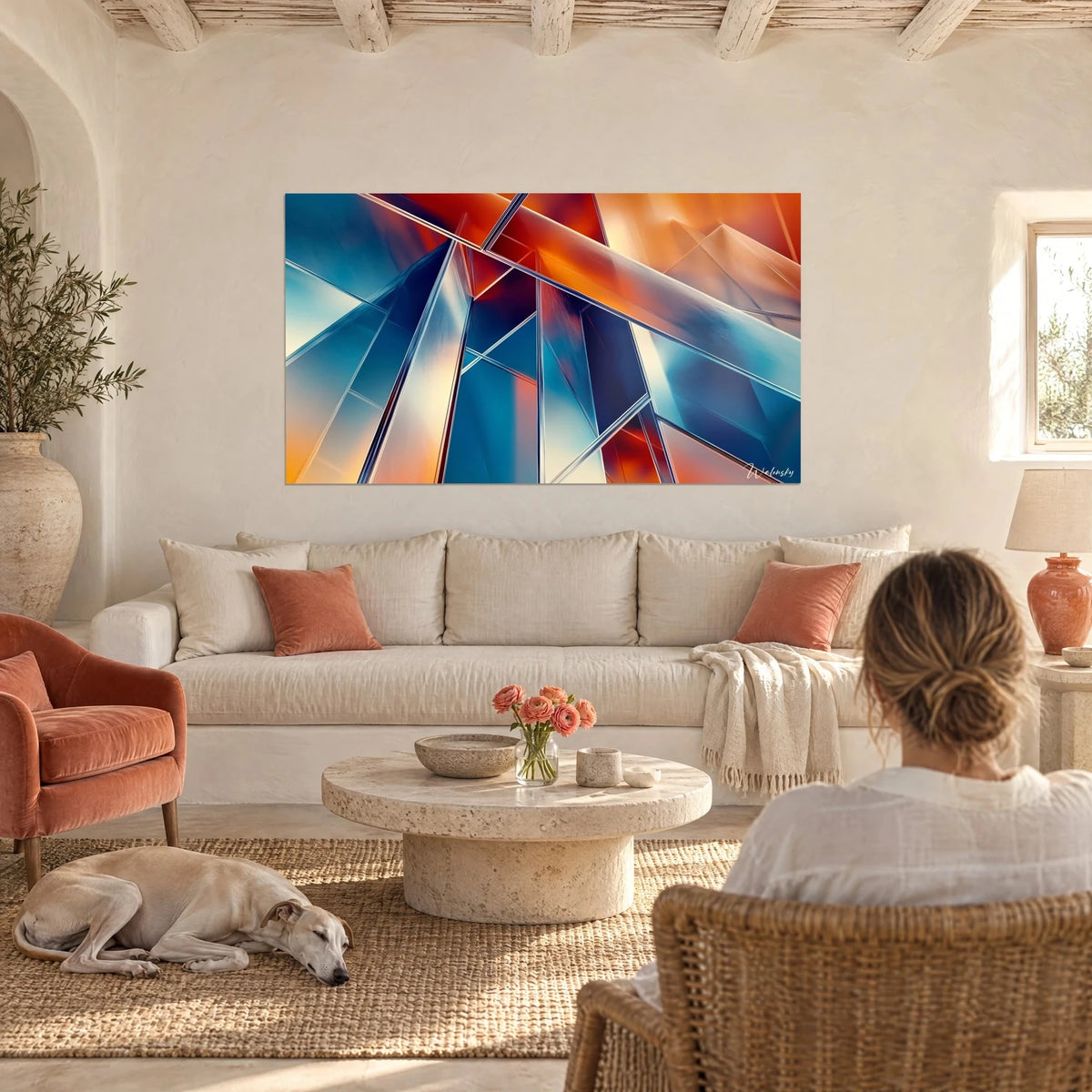 Wall art broken glass panels in orange and petrol blue, two people and a greyhound in front, above a sofa in a bright living room