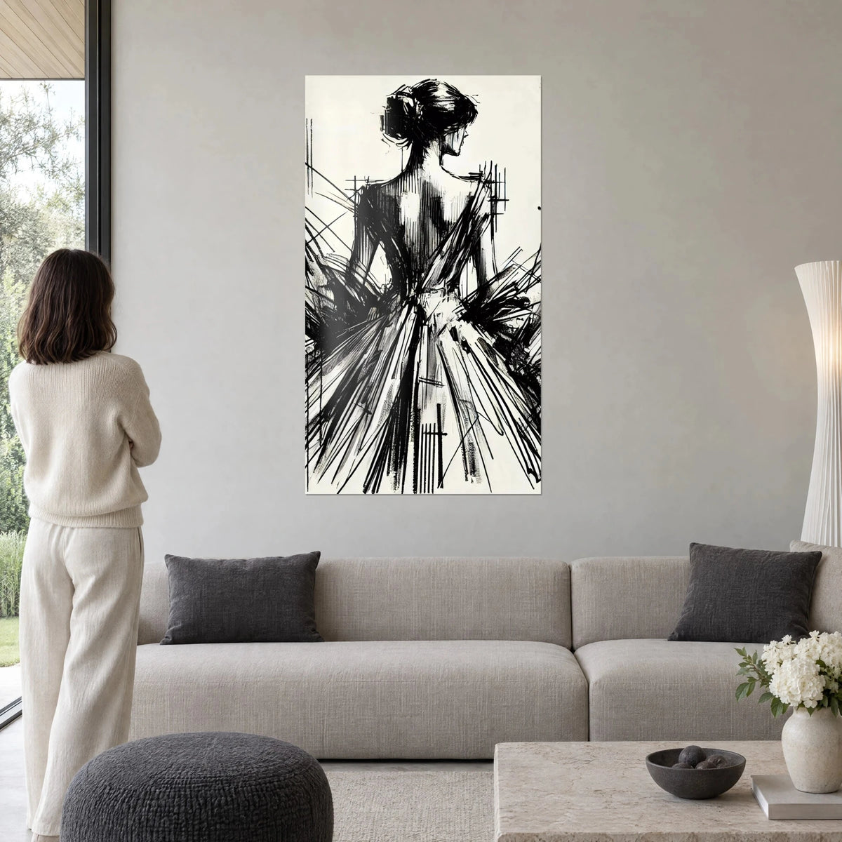 Tableau danseuse de dos en encre noire sur fond ivoire, jupe en traits cinglants, au-dessus d'un canapé dans un salon lumineux