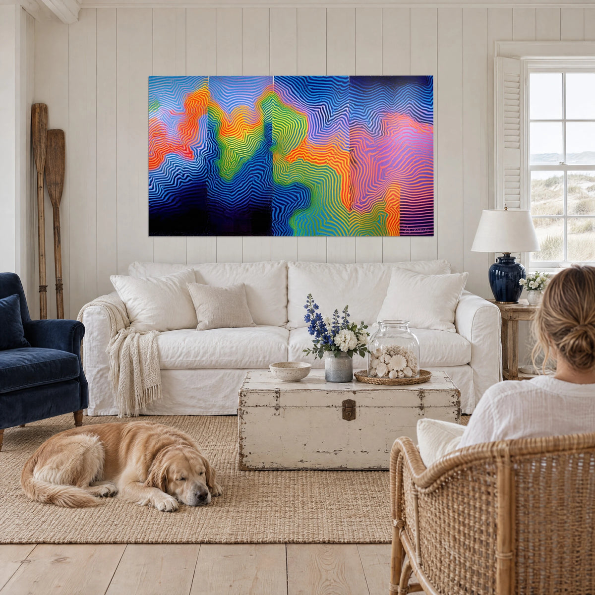 Tableau lignes ondulantes bleu cobalt et orange vif, panorama Op Art, retriever couché, au-dessus d'un canapé dans un salon lumineux