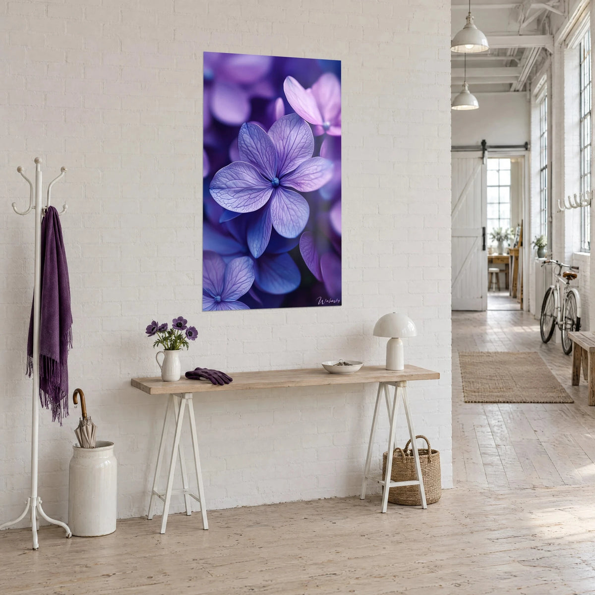 Cuadro pétalos de lila azul-violeta de venas delicadas, sobre una pared blanca encima de una consola de madera en un loft