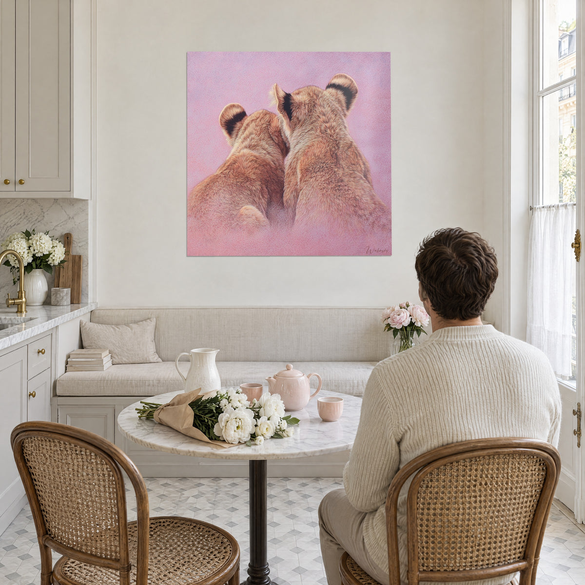 Schilderij jonge leeuwen schouder aan schouder, koperkleurige en okerkleurige vacht op roze achtergrond, bekeken door een man van achteren in een crèmekleurige trui