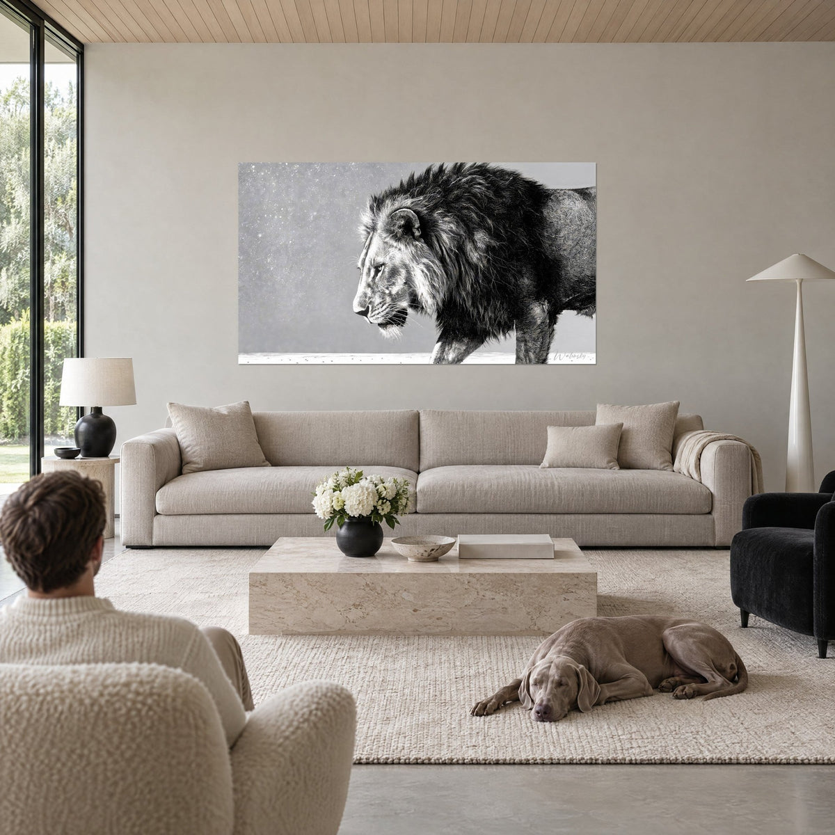 Wall art of a lion with a dark mane walking forward, pearl grey and black profile, above a sofa in a bright living room