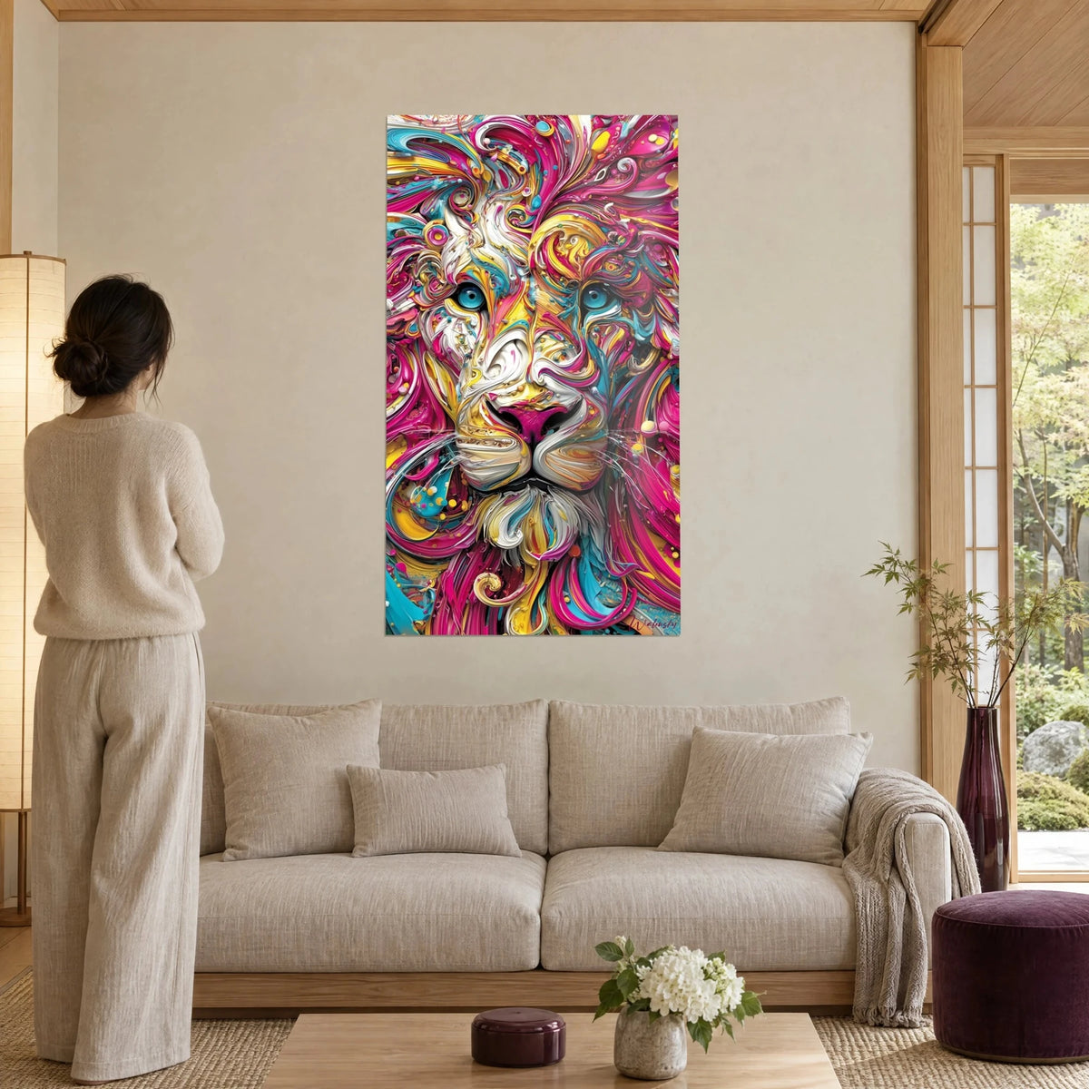 Wall art lion with fuchsia and sun-yellow mane, turquoise eyes, woman seen from behind, above a sofa in a bright living room