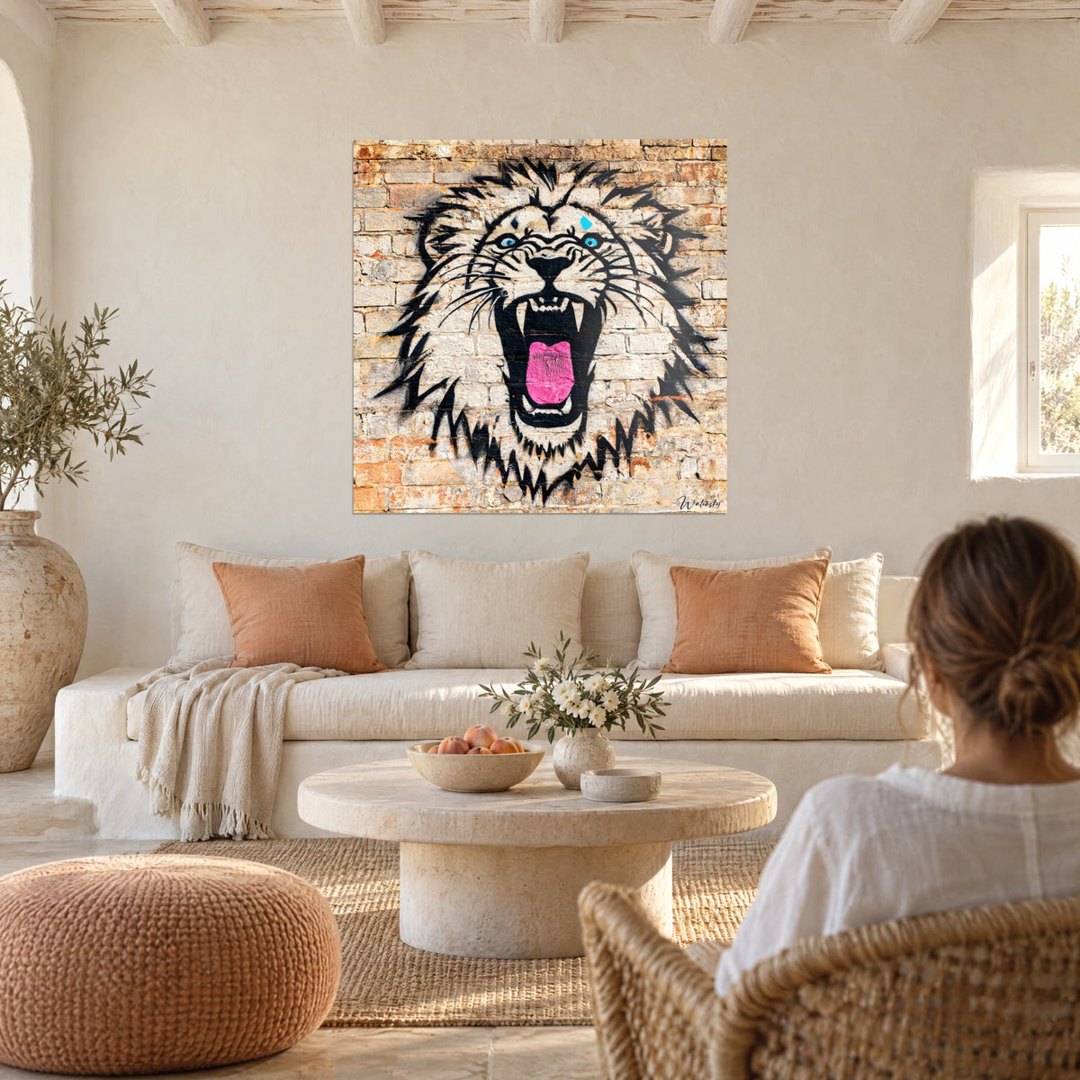 Tableau lion rugissant, gueule noire et langue rose sur briques ocre, au-dessus d'un canapé dans un salon lumineux