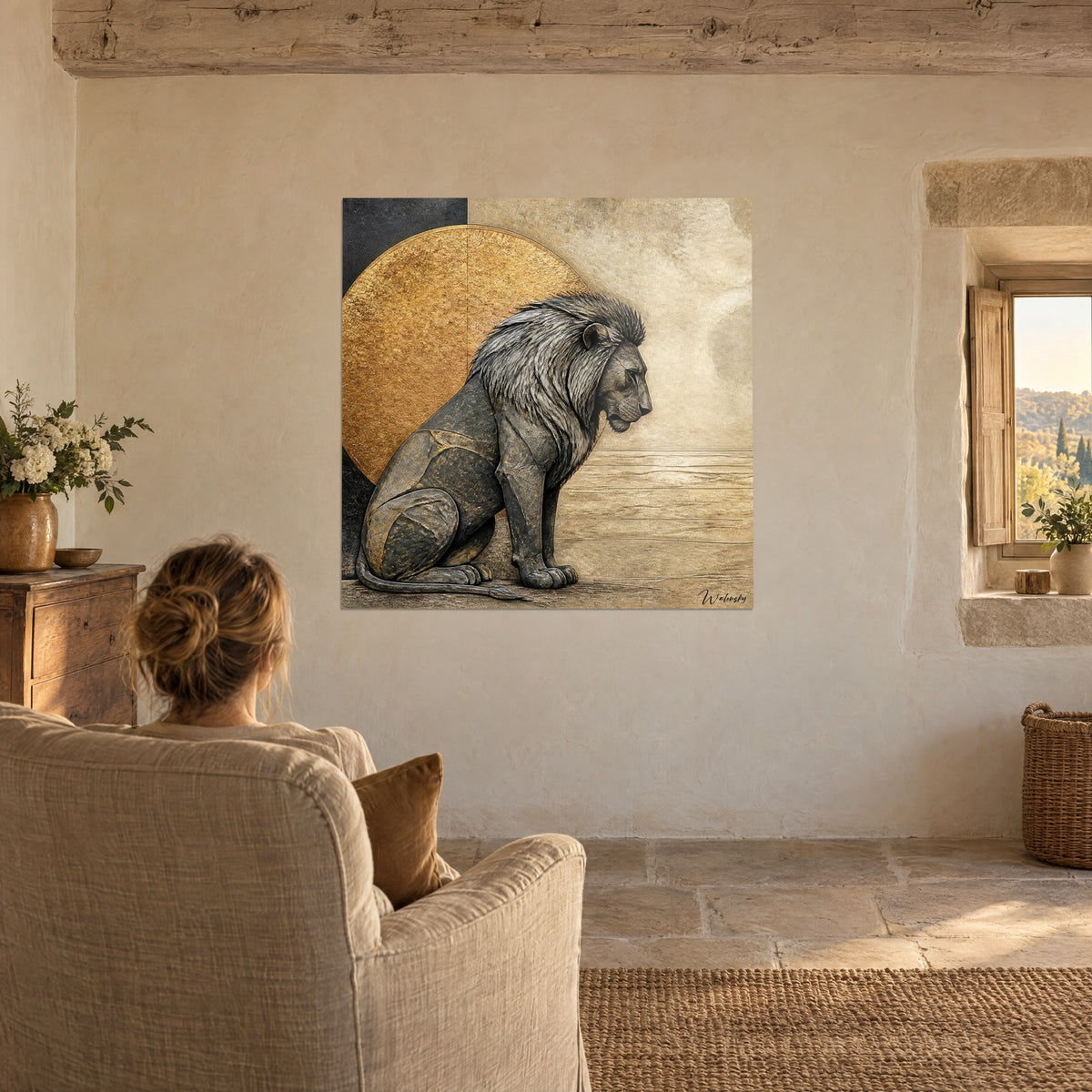 Tableau lion pensif de profil, pelage anthracite, disque or antique et mur beige, une femme de dos dans un fauteuil crème, maison de campagne