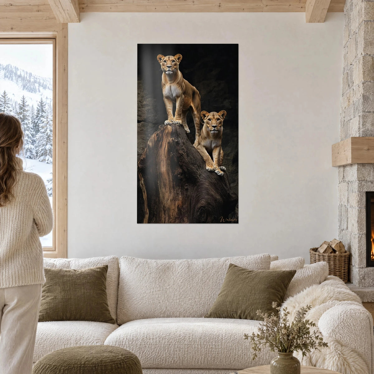 Gemälde einer goldenen Löwin auf einem braunen Baumstamm, ihre Gefährtin zu ihren Füßen vor schwarzem Hintergrund, über einem Sofa in einem lichtdurchfluteten Wohnzimmer