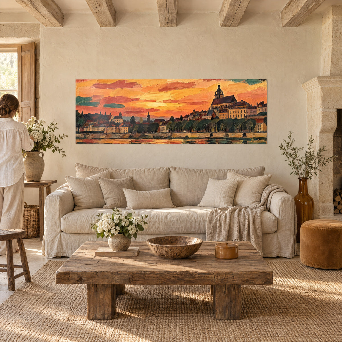 Quadro città fluviale sotto un cielo arancio e rosso, campanile scuro, riva ocra, sopra un divano in un soggiorno luminoso