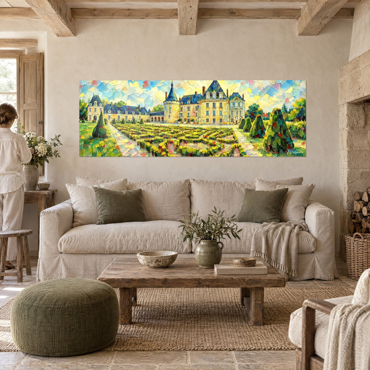 Gemälde Schloss in Gelb mit blau schiefergedeckten Dächern und grünen Beeten in Messerstrichen, über einem Sofa in einem hellen Wohnzimmer
