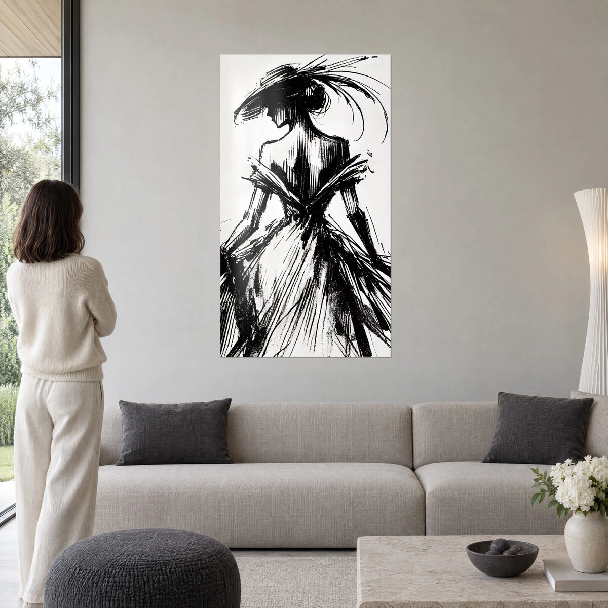 Tableau silhouette de mode à chapeau à plumes, encre noire sur fond blanc, au-dessus d'un canapé dans un salon lumineux