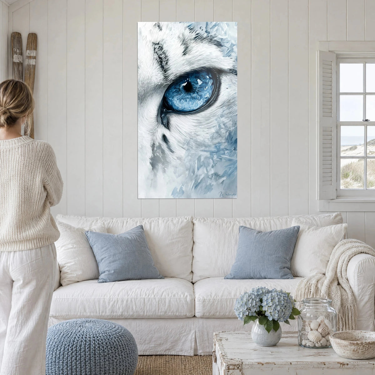 Tableau félin des neiges à l'iris bleu glacier, fourrure blanche et grise, au-dessus d'un canapé dans un salon lumineux
