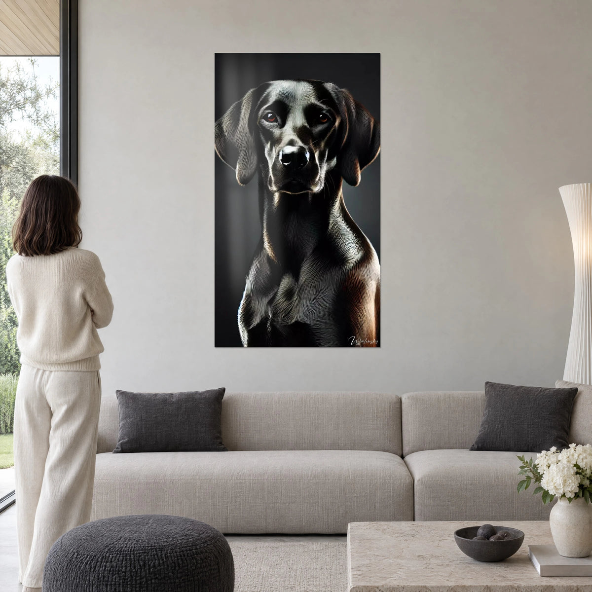 Cuadro retrato de perro negro de ojos ámbar, pelaje brillante sobre fondo antracita, encima de un sofá en un salón luminoso