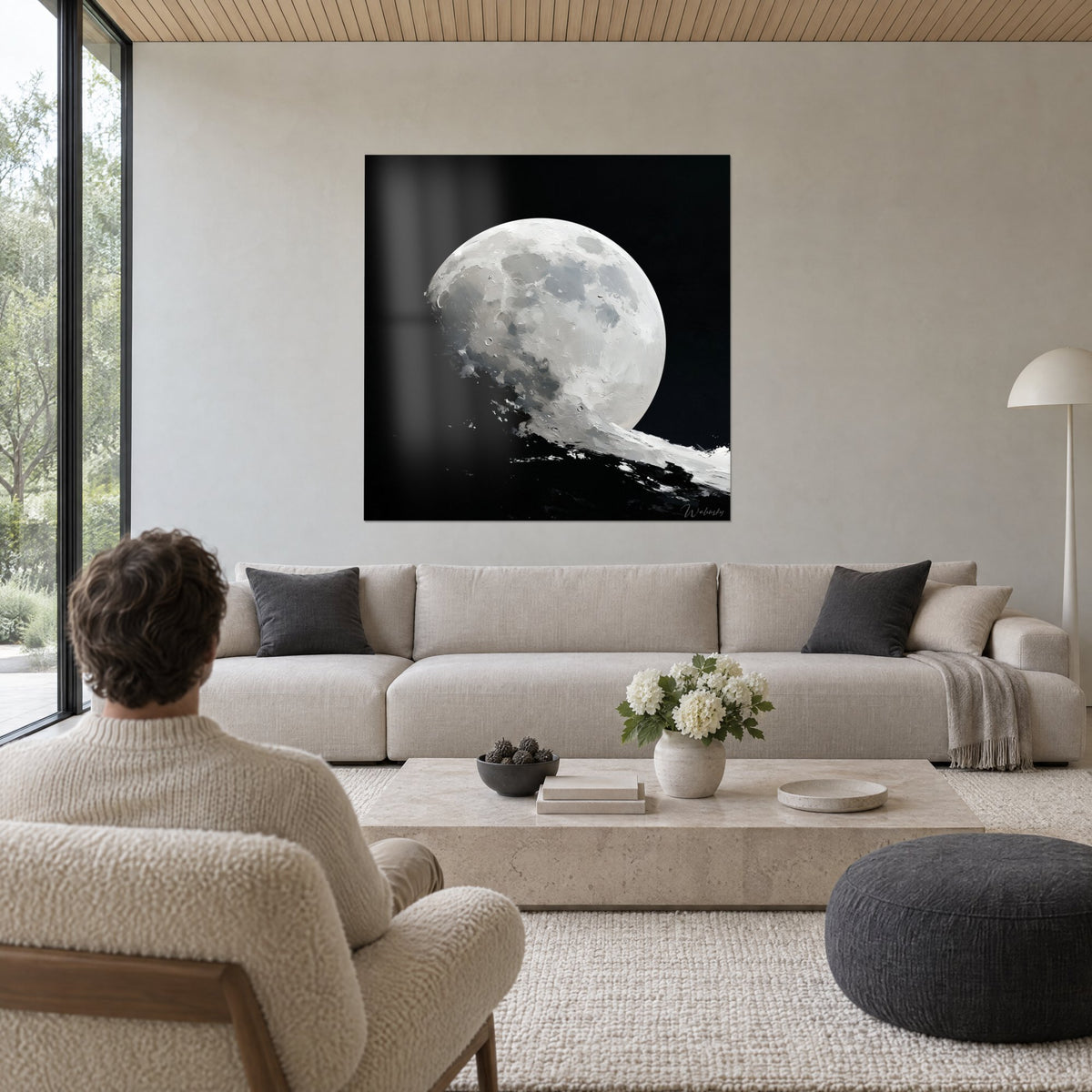 Wall art cratered full moon, creamy white and pearl grey on black background, above a sofa in a bright living room